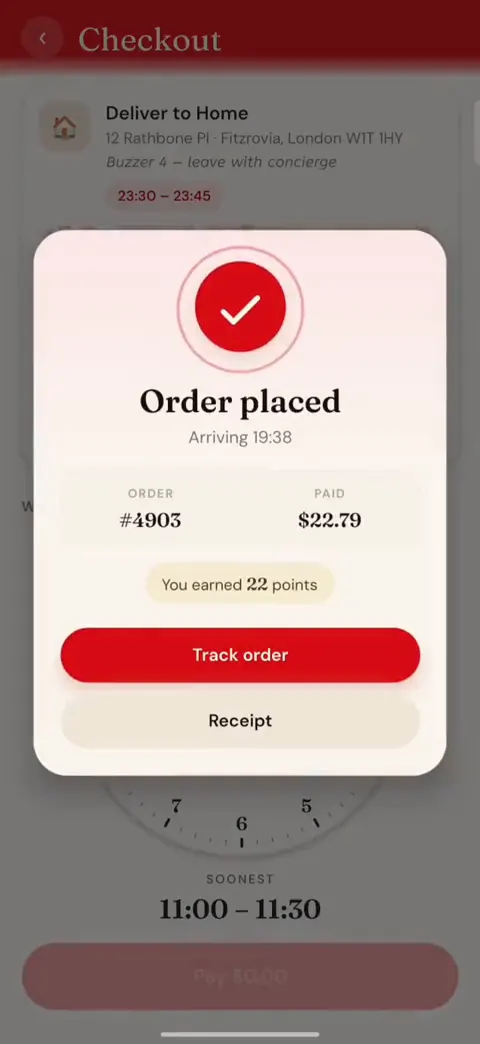 La confirmation de commande par-dessus l'écran de commande : une coche, l'heure d'arrivée, le numéro de commande et le montant payé, les points de fidélité gagnés, et des boutons pour suivre la commande ou voir le reçu.